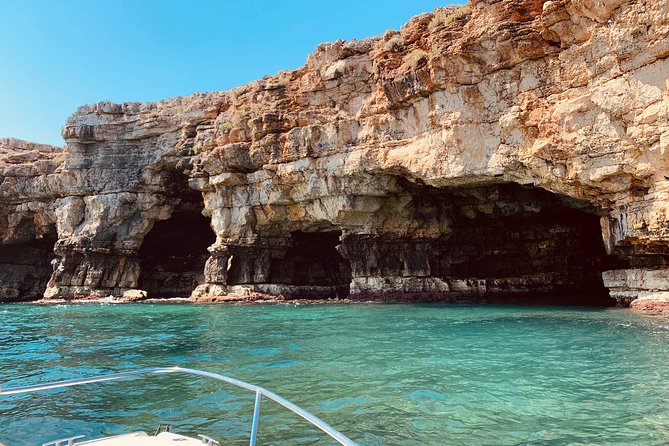 Boat tour of the Polignano a Mare caves with aperitif - Lama Monachile and the statue of Domenico Modugno